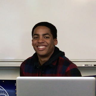 Christian Dawkins sits in front of a whiteboard.