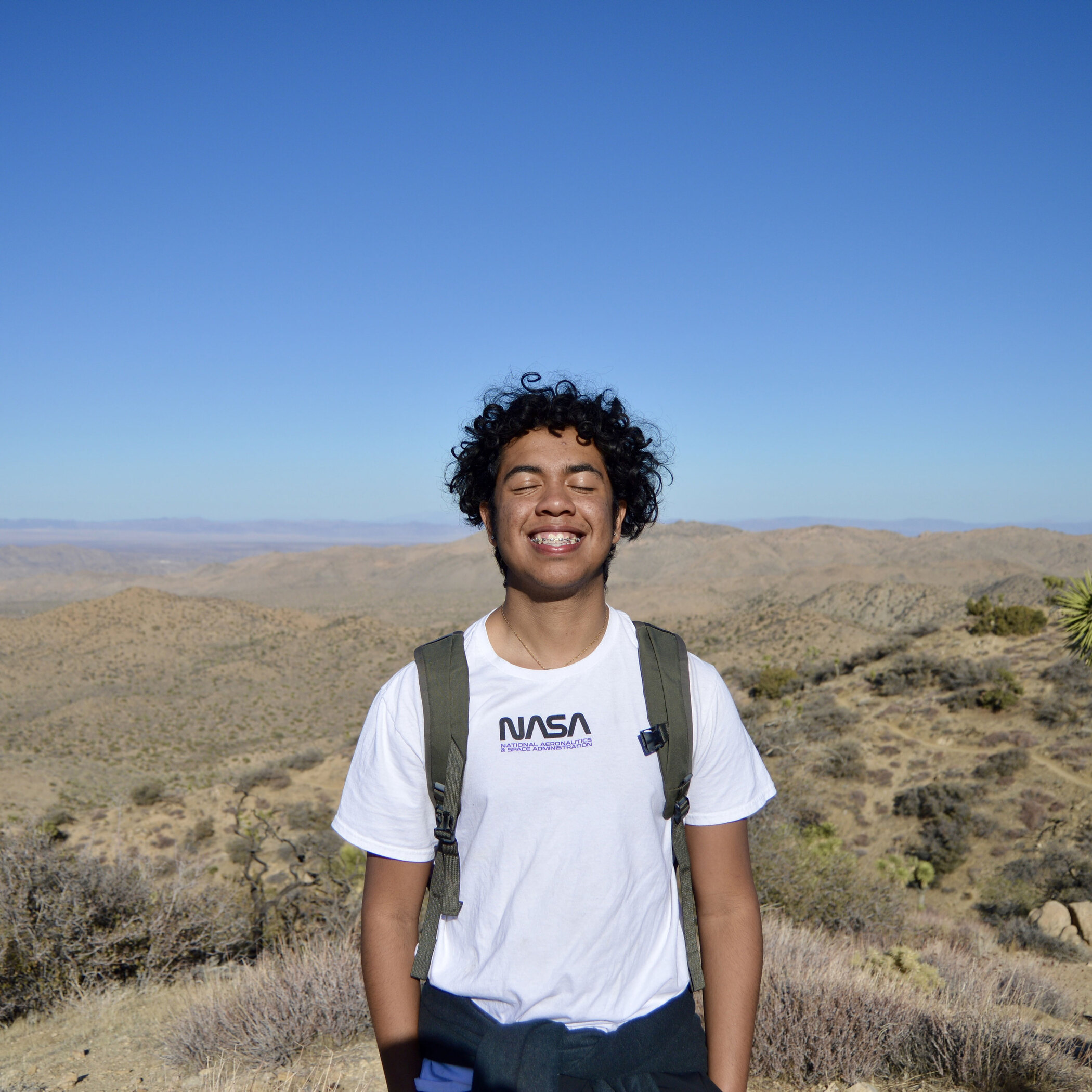 Emmanuel Mariano stands in a grassy field.