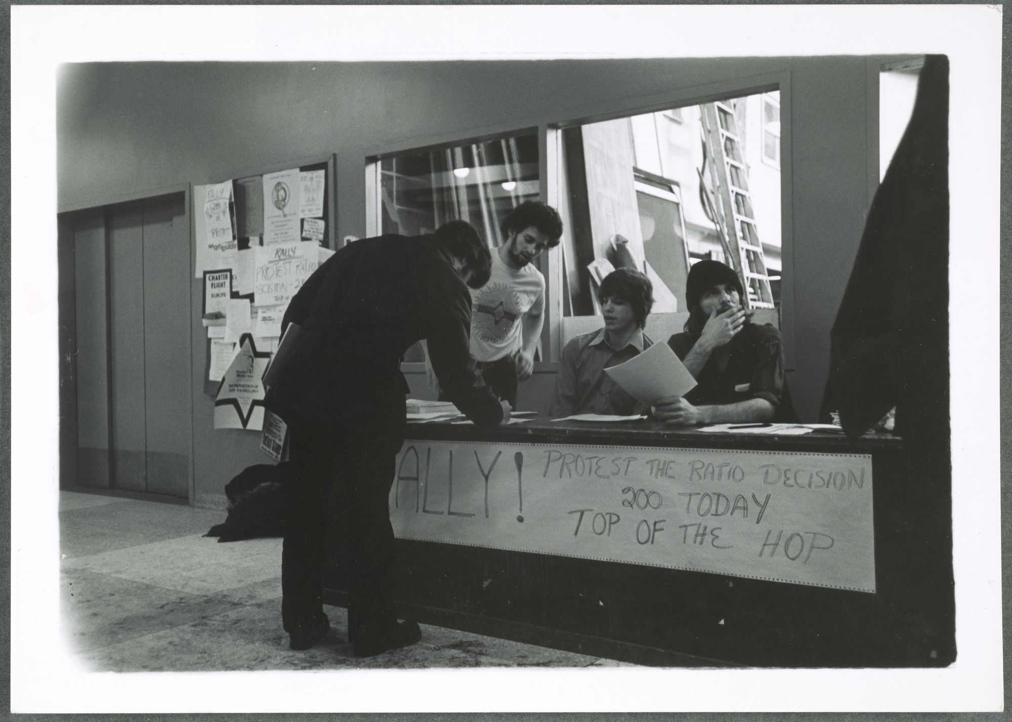 A black-and-white photo of students signing up in support of sex-blind admissions.