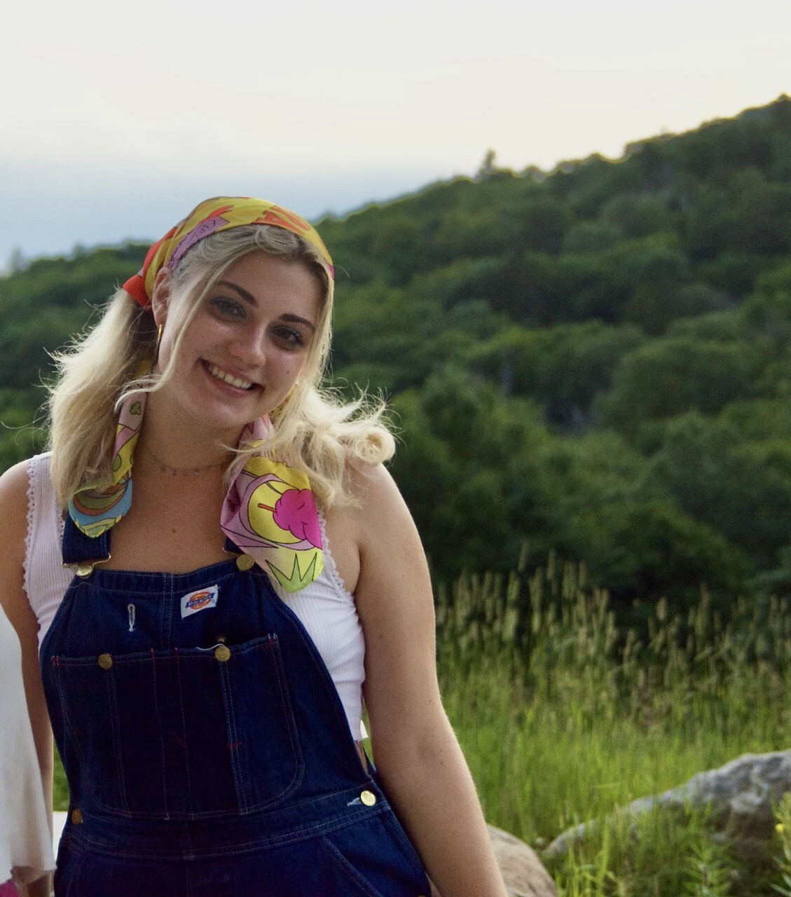 Leeza Petrov sitting on a grassy mountainside