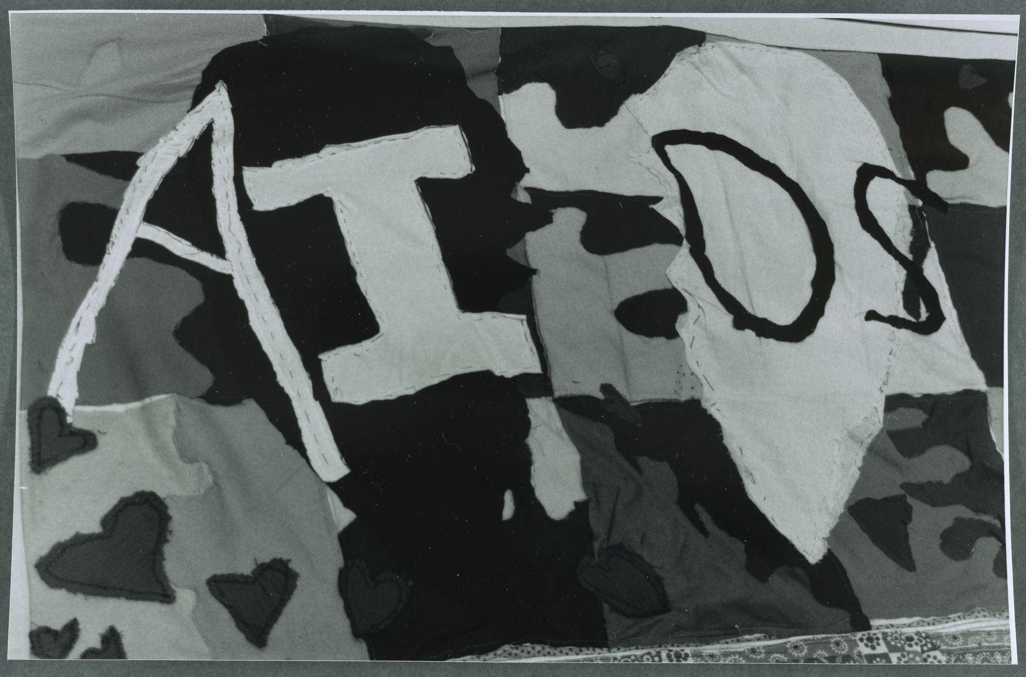 A panel of the AIDS quilt with irregularly-shaped letters spelling "AIDS."
