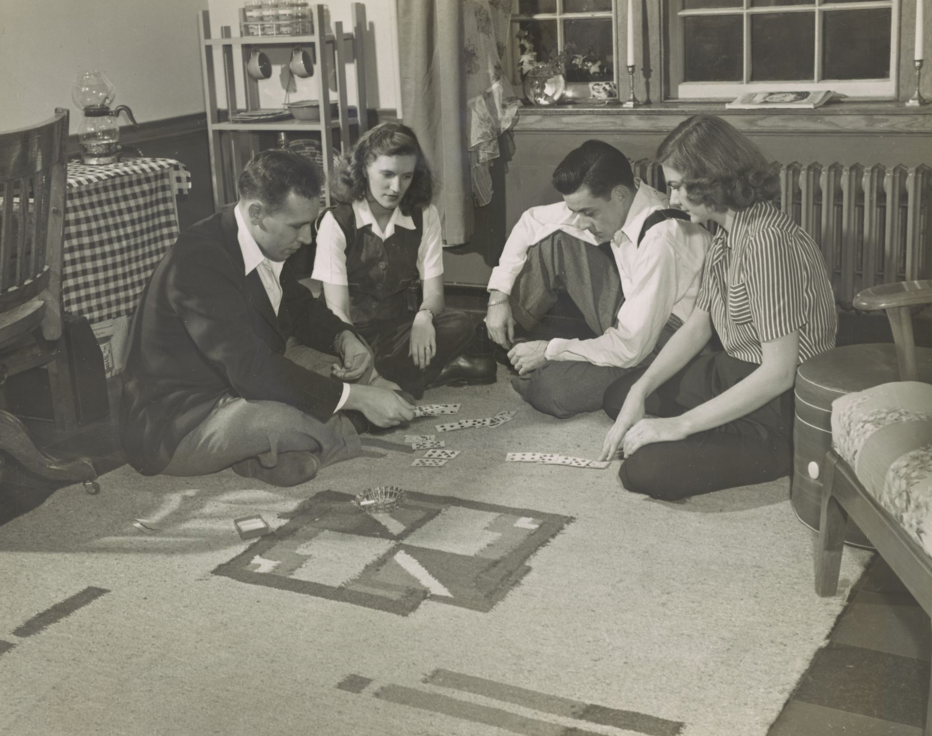 Two couples play cards in veterans housing