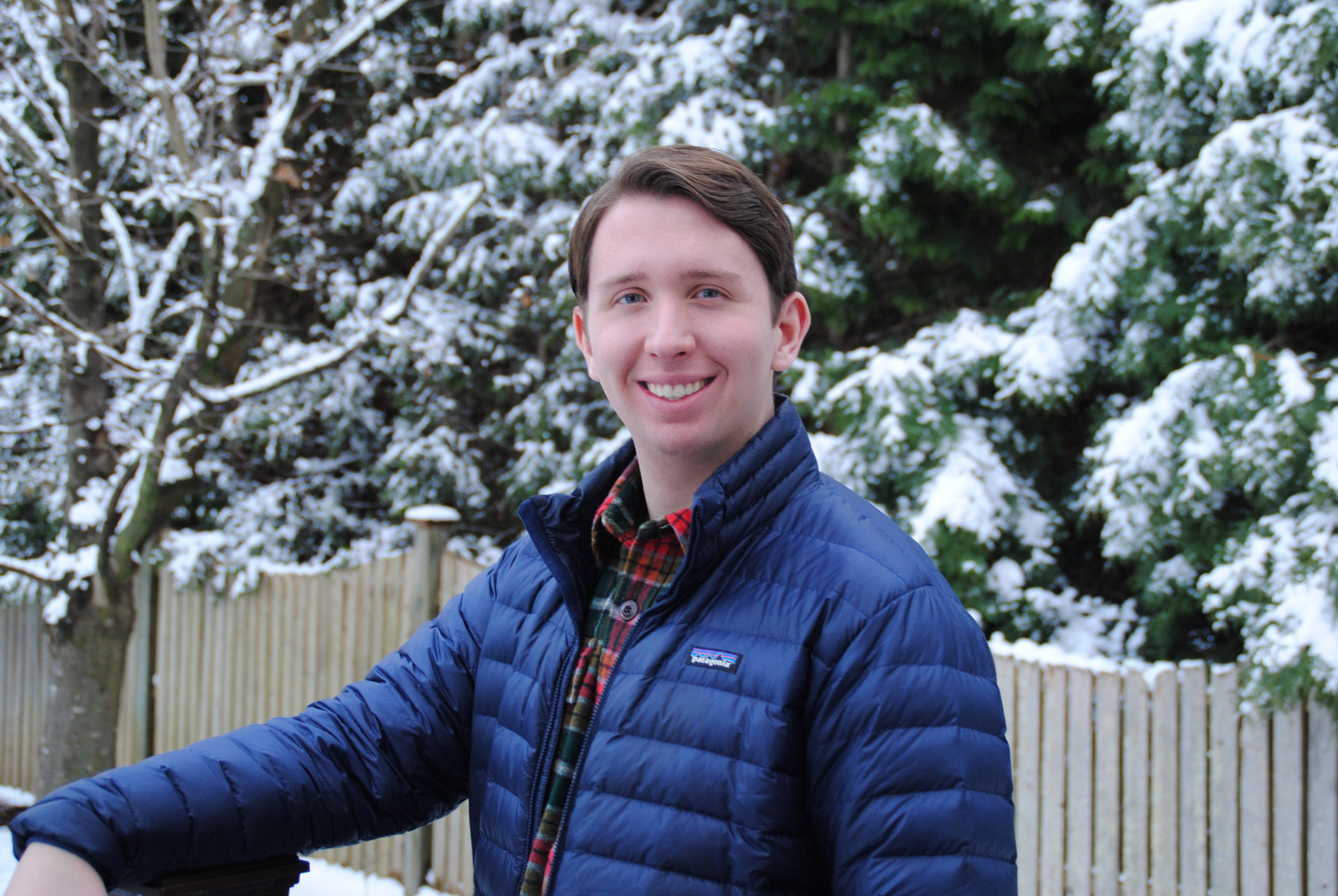 Matt Skrod '24 wearing a winter coat in front of snow covered trees