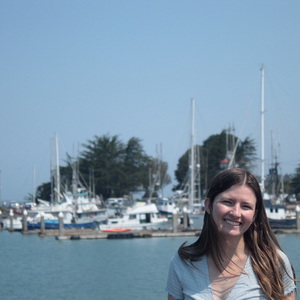 Sara Pickrell '24 stands in front of a harbor on a sunny day