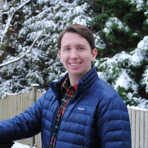 Matt Skrod '24 wearing a winter coat in front of snow covered trees